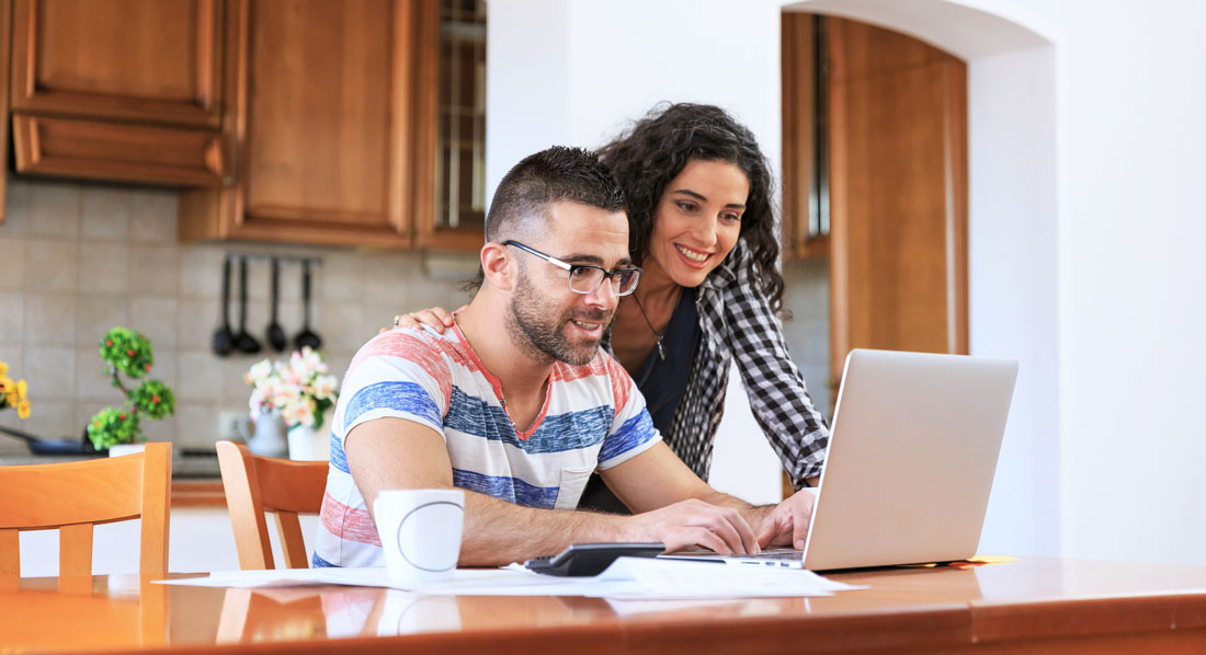 Eine Frau und ein Mann rechnen etwas zusammen am Laptop aus
